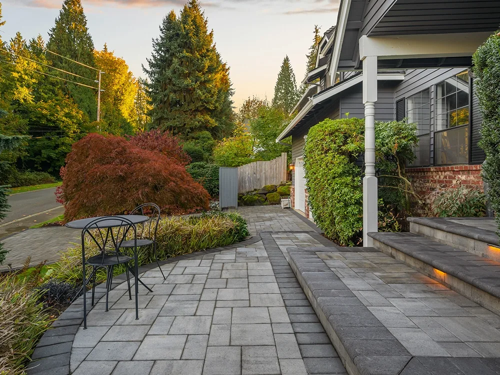Beautiful front patio with paving stone steps and built-in lighting in Oregon. 