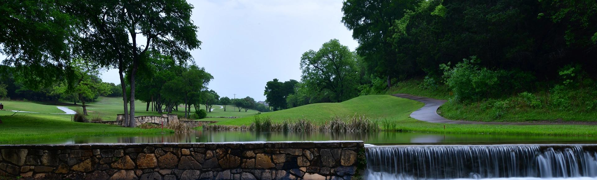 Gold course cart path crossing a small stream late in the evening after a rain shower in Leander TX.