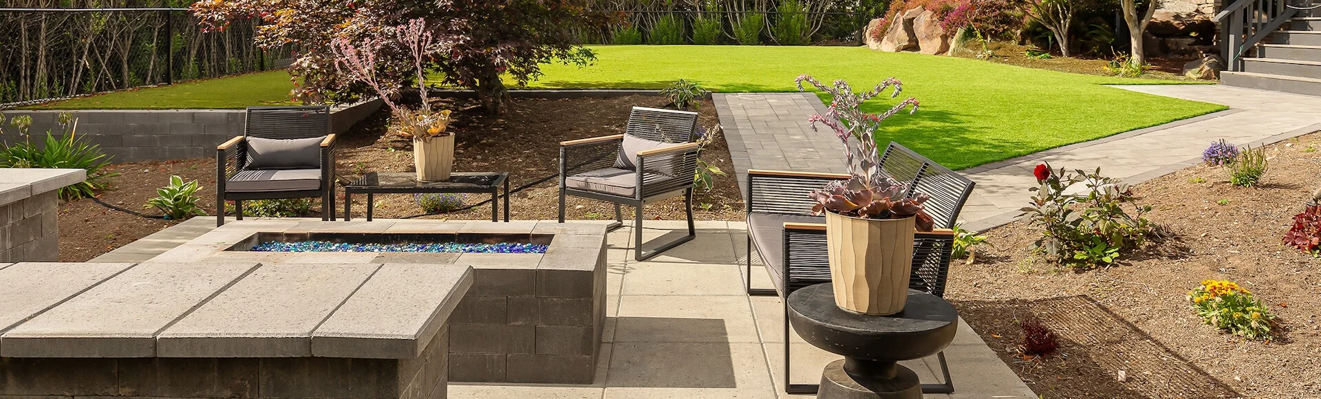 PNW backyard renovation with paver walkways, fire pit, and sitting walls