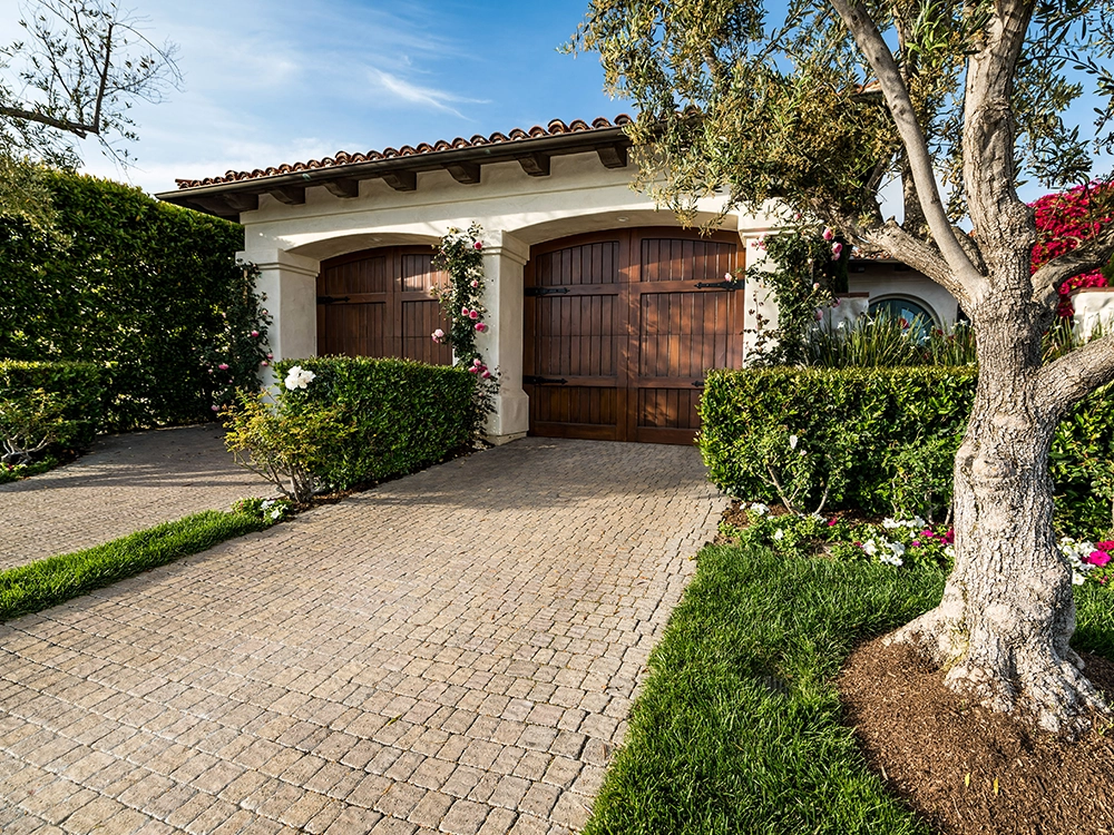 Paving stone driveway in Southern California with beautiful wooden garage doors. 