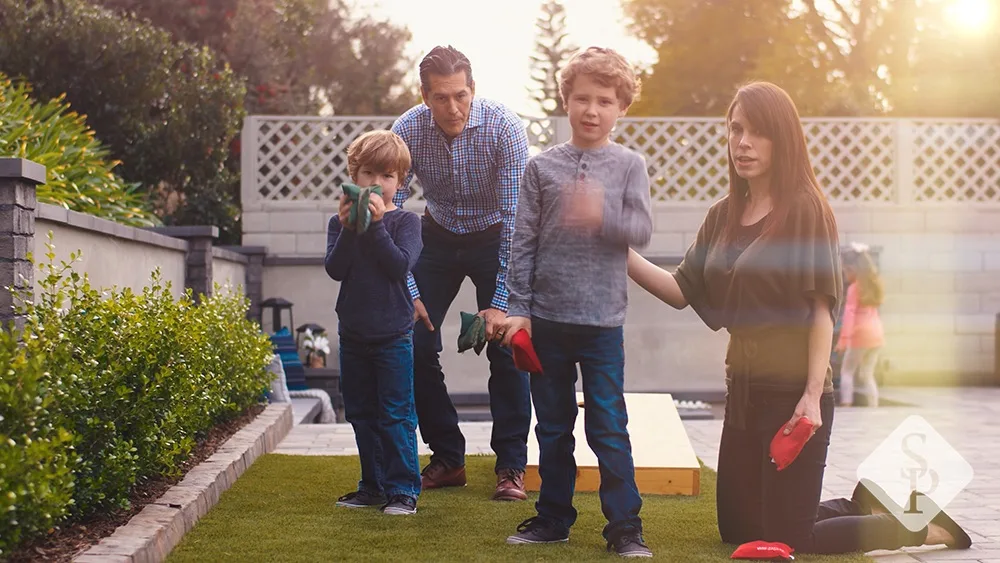 family playing cornhole