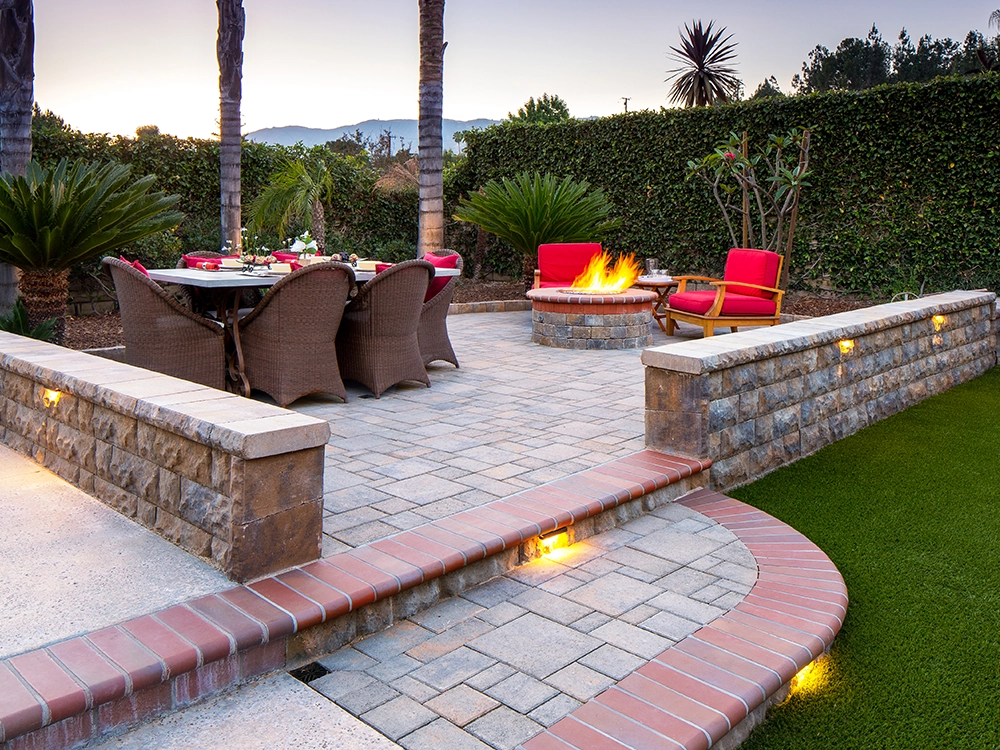 Paver patio with turf and steps with lighting.