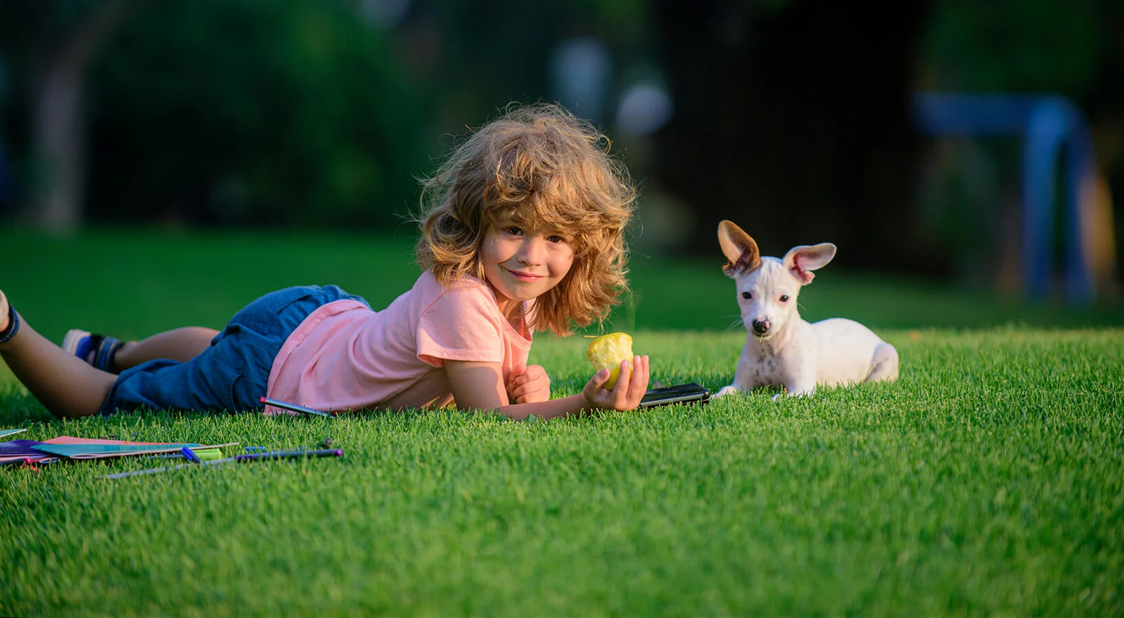 Child and puppy on artificial turf lawn