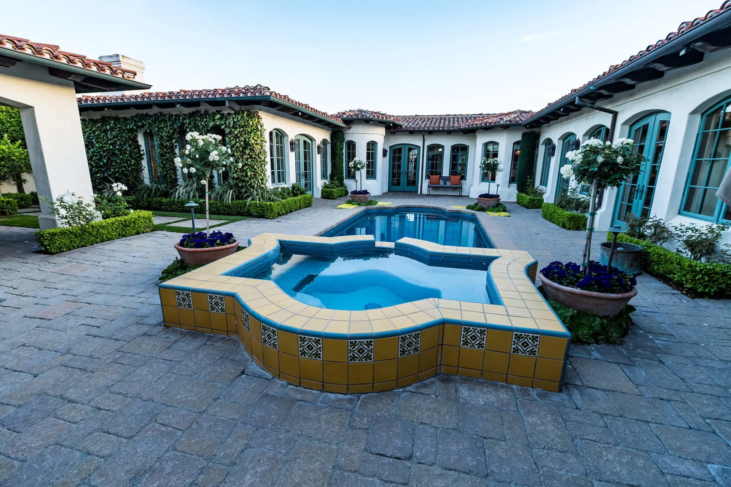 Paving stone courtyard with yellow tile pool detailing 