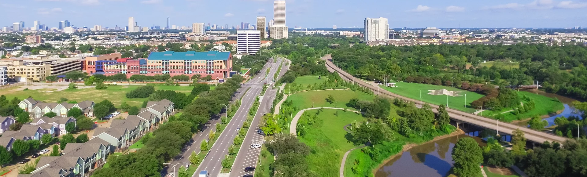 Aerial view of west-central area in Houston from Buffalo Bayou Park. Foreground is historic Fourth Ward, Allen Parkway, Memorial Parkway, Buffalo Bayou river, mid-town high-rise buildings in distance