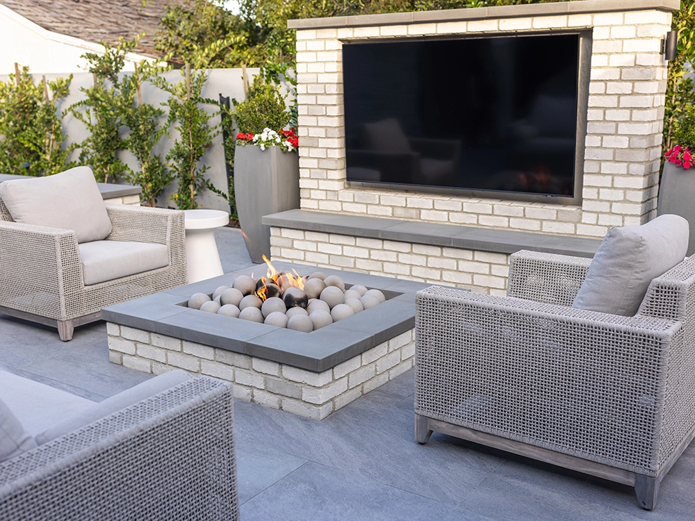 Backyard patio made of beautiful marble stone. Features built-in fire pit and TV. 
