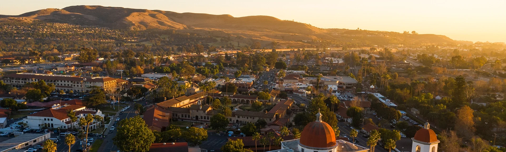 Sunset aerial view of the Spanish Colonial era mission and surrounding city of downtown San Juan Capistrano, California, USA.