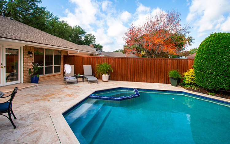 Texas backyard pool with fence and paving stone pool deck