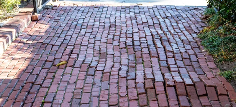 uneven brick driveway that is decaying