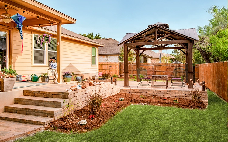 Free-standing pergola in a Texas backyard. Includes paving stone landscaping with stone patio and planters. 