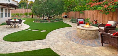 yard with pavers, turf, and firepit