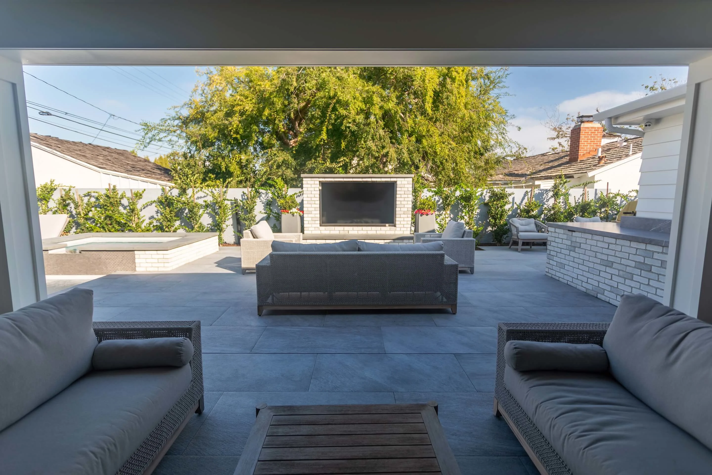 Covered outdoor living room with large format pavers and patio furniture
