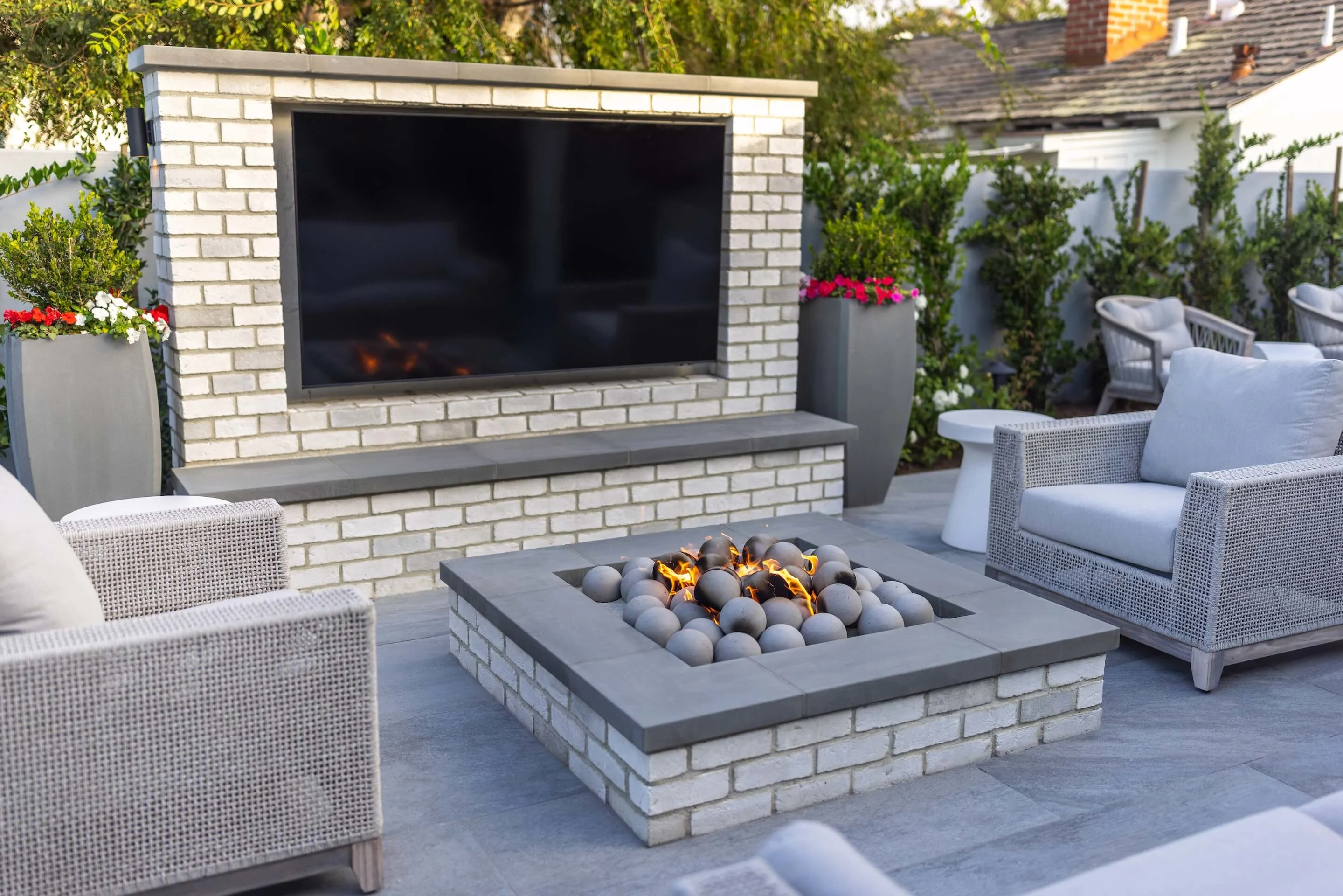 Modern square fire pit with outdoor tv and paving stone patio outdoor living space