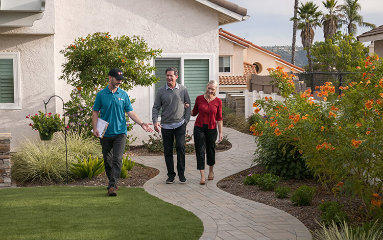 System Pavers Design Consultant walks with homeowners