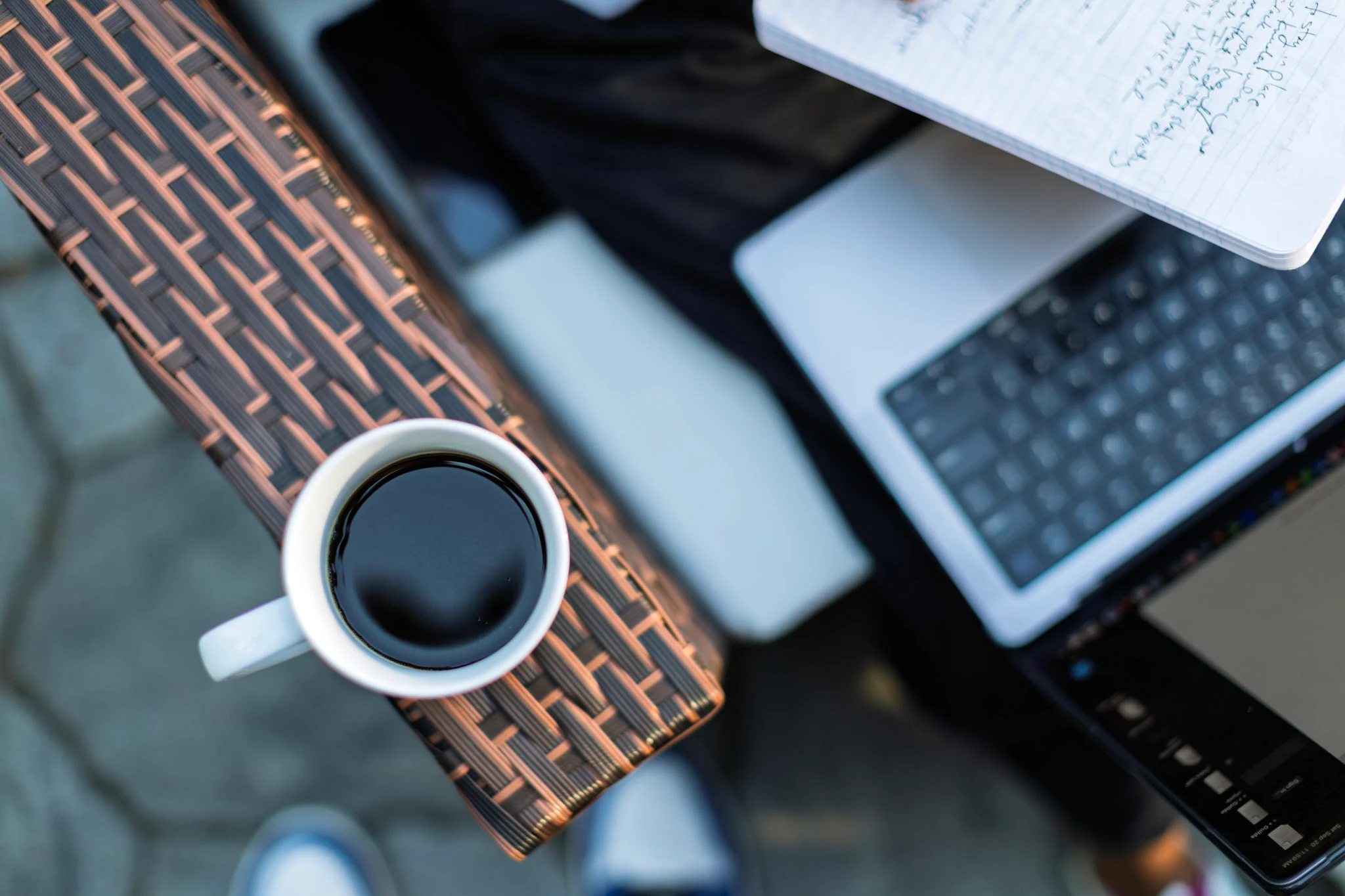 Cup of coffee and computer on paver patio