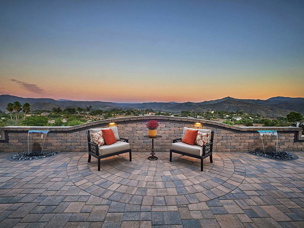 Paver patio, walls, outdoor seating, water feature, mountain view, outdoor lighting, backyard, setting sun, California, Arizona, evening