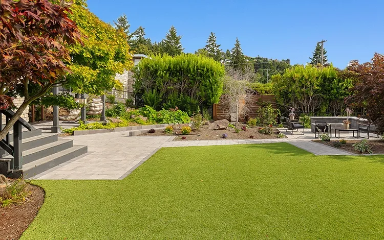 Large artificial turf lawn in a PNW backyard with paver patio.