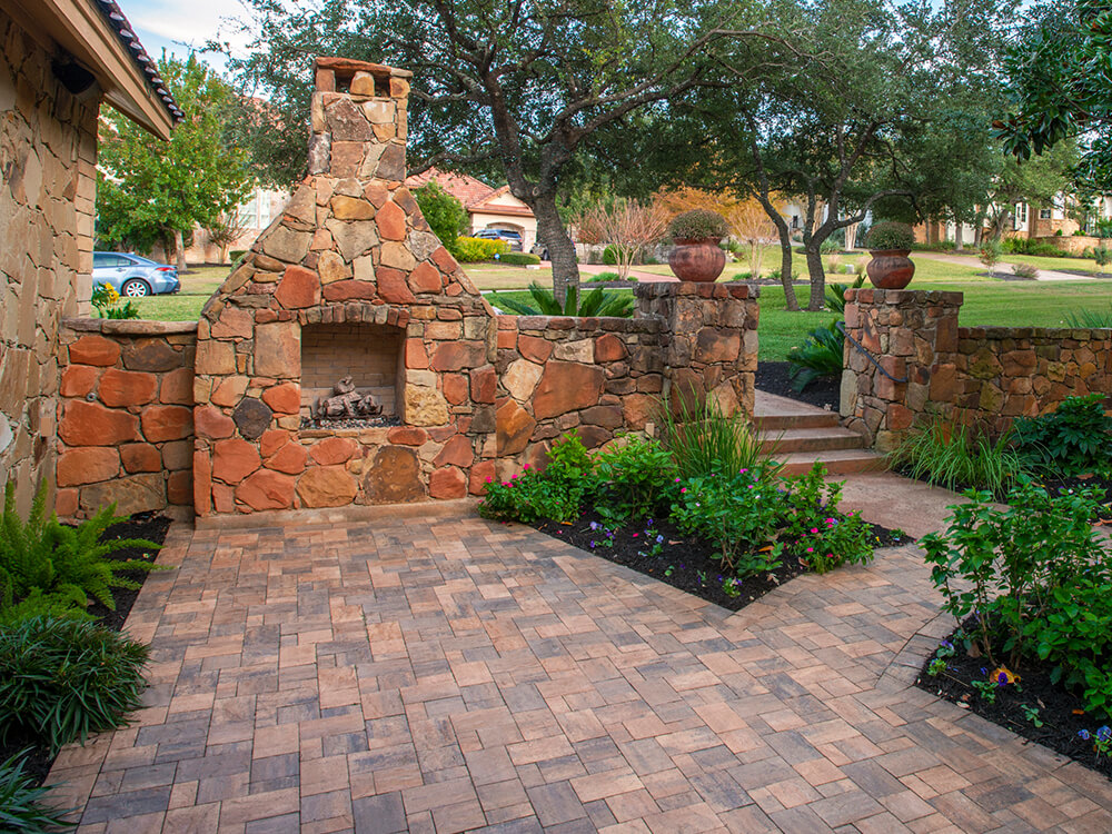 Built in fireplace on a patio with landscaping
