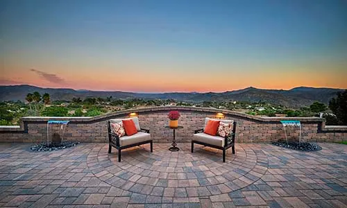 Paver patio, walls, outdoor seating, water feature, mountain view, outdoor lighting, backyard, setting sun, California, Arizona, evening