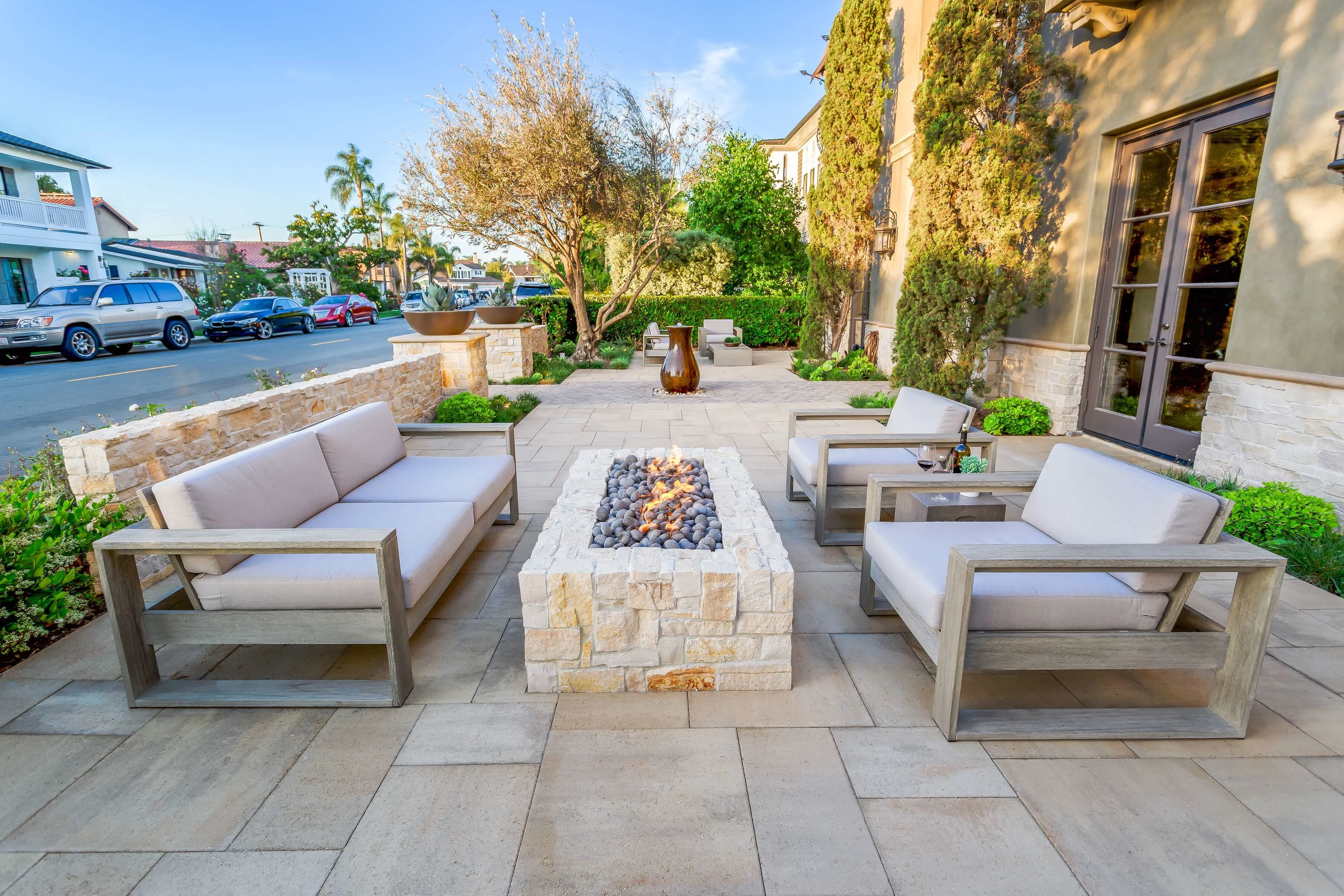 Front yard paver courtyard with privacy walls and patio seating around a fire pit