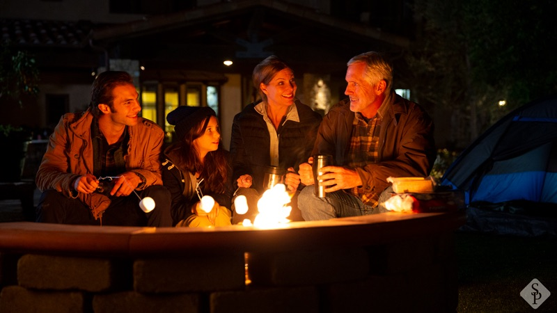 family making s'mores at a fire pit