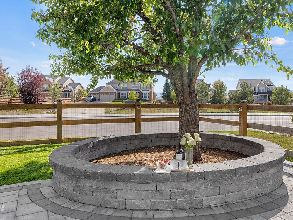 Stone retaining wall surrounding a tree in a home backyard in Colorado. 