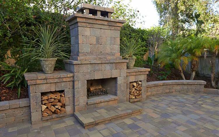 Outdoor fireplace, paver patio, retaining wall, wood, wood-burning fireplace, outdoor living, backyard, paving stones, California, daytime
