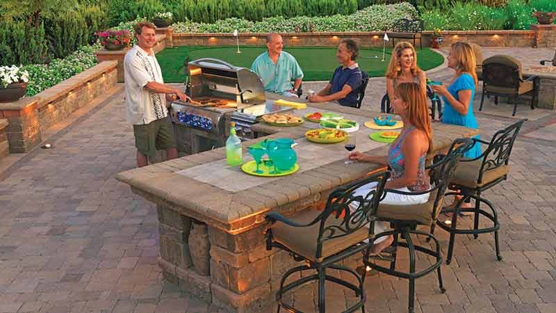 people at a bbq island on a paver patio