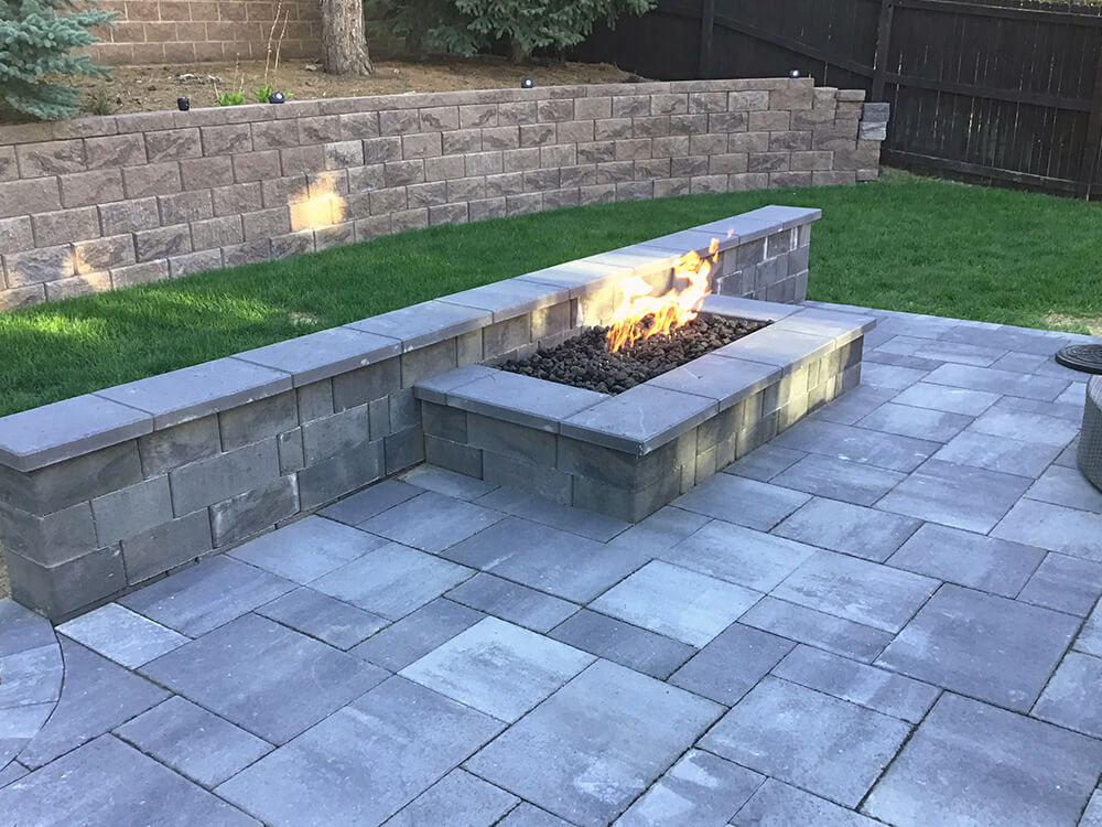Small paver patio with built-in fire feature and bench in Denver, Colorado