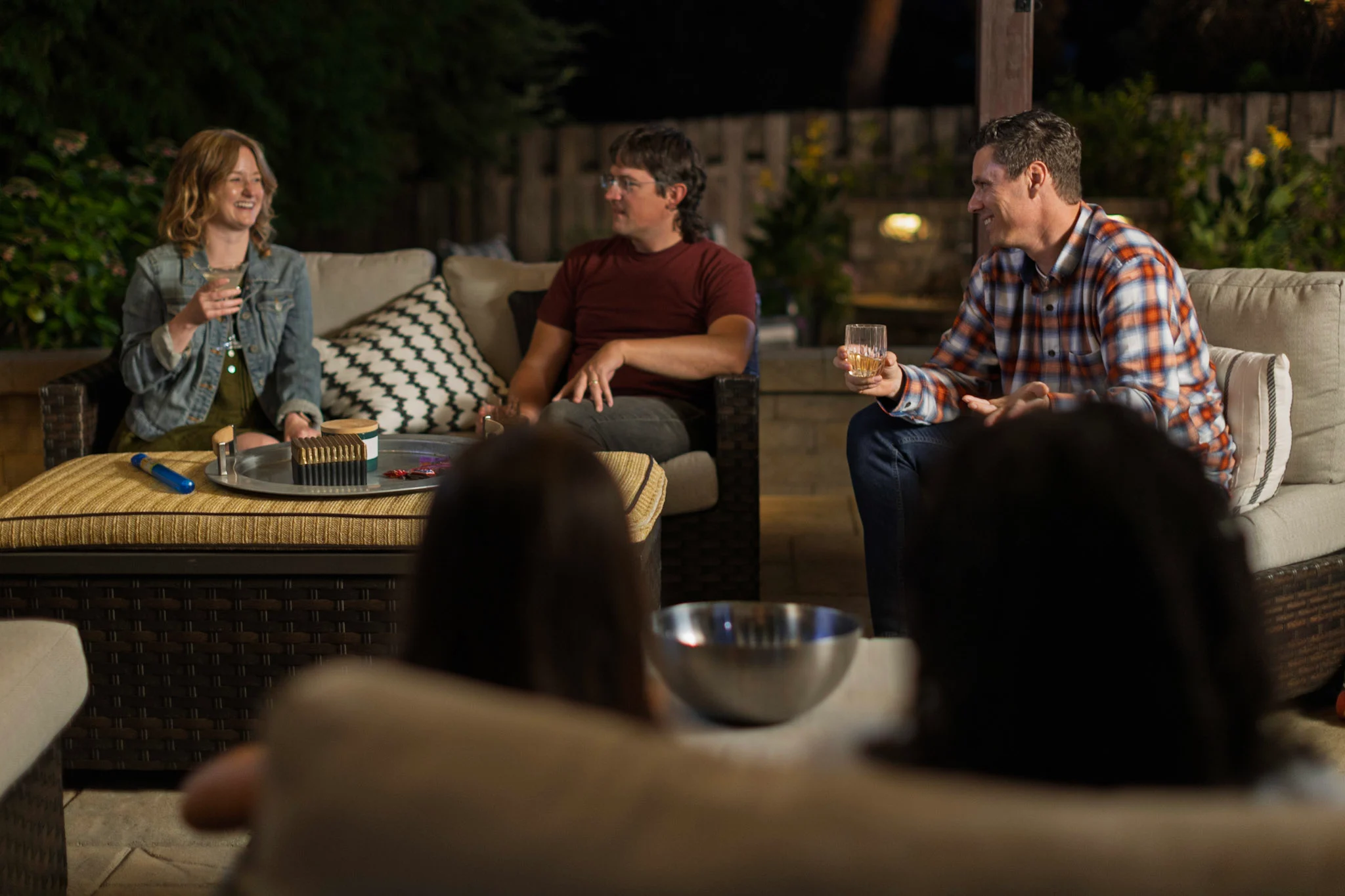 Friends laughing, talking and having cocktails under the pergola 