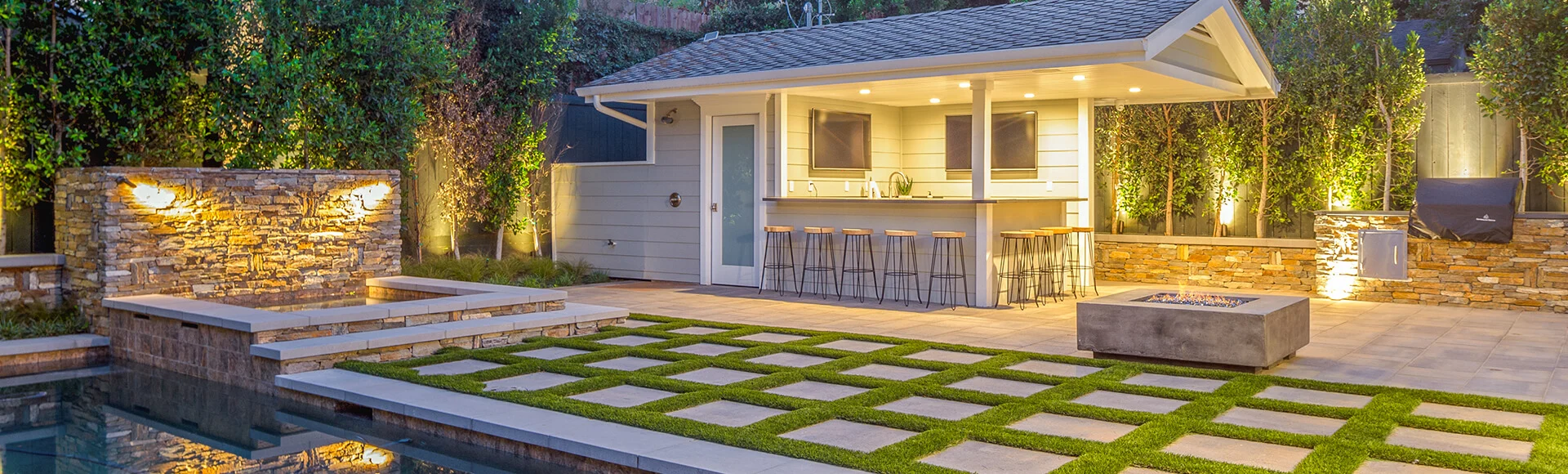 Pool deck with water feature, turf, pavers and outdoor kitchen