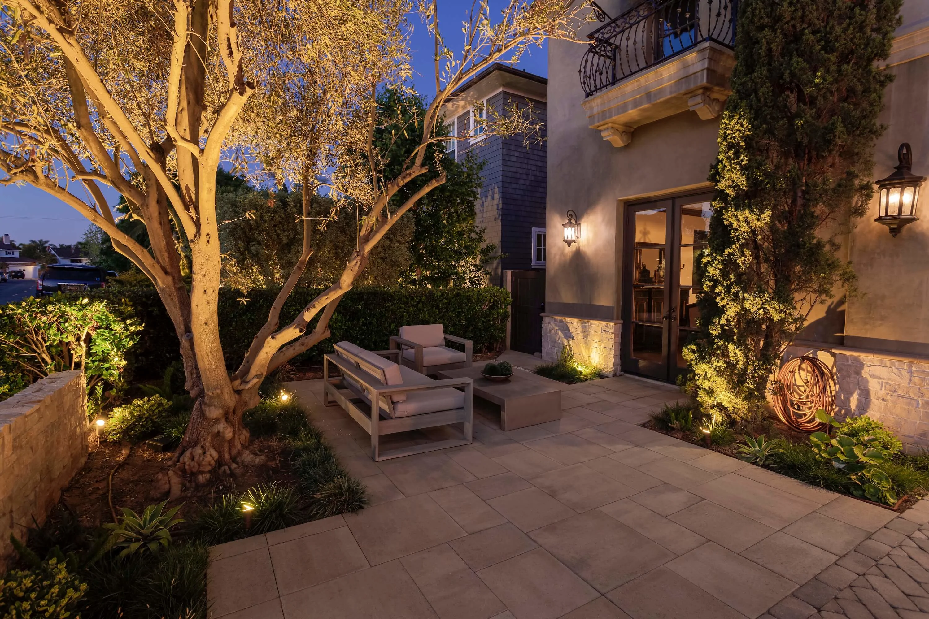 Paver courtyard with outdoor landscape lighting and patio seating area