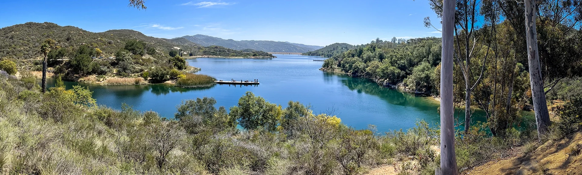 Landscape view of Escondido, California. Dixon lake surrounded by green trees and bushes in background of greenery mountains in Escondido. 