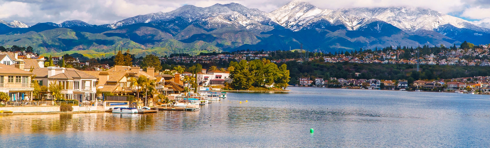 Scenic Lake Mission Viejo with snow capped Santa Ana Mountains in the distance, after epic snowstorm in Southern California