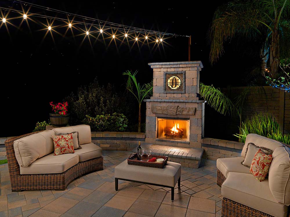 Outdoor fireplace, cozy, fire, lit, wine, paver patio, patio furniture, outdoor living, outdoor lighting, backyard, fire, paving stones, California, night