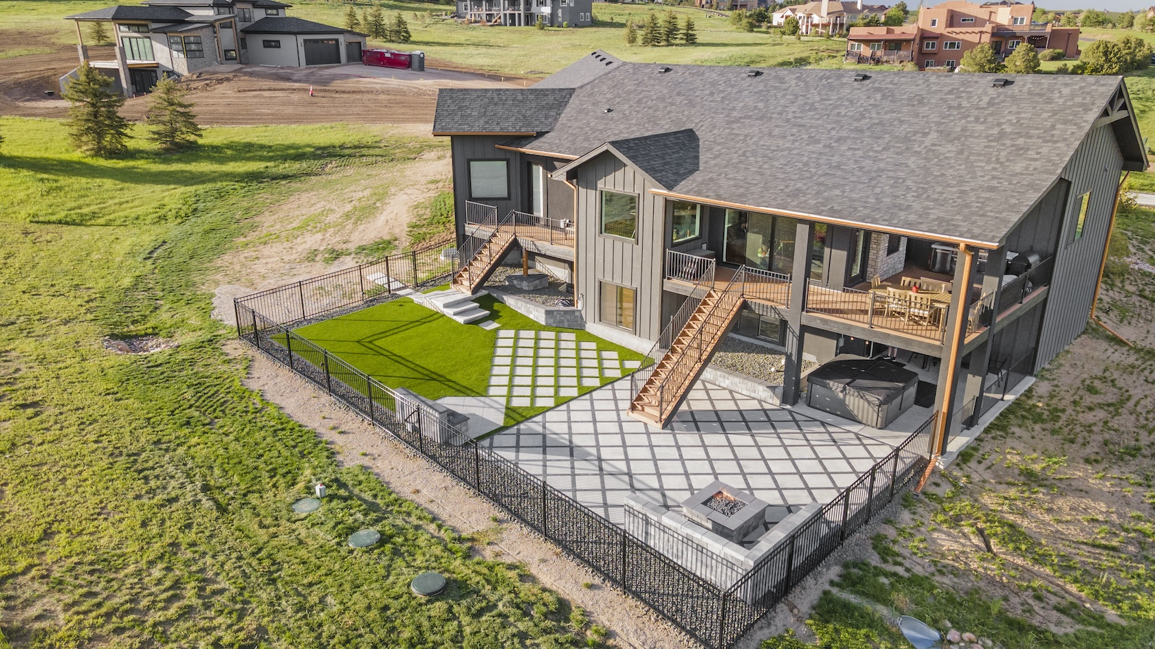 Ariel view of permeable paver backyard remodel with multiple decks and fire pit