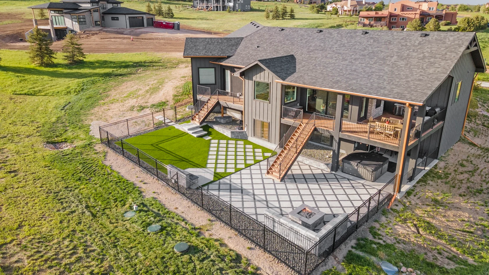 Ariel view of permeable paver backyard remodel with multiple decks and fire pit