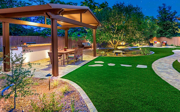 Incredible backyard with large wooden pergola, turf lawn, paving stone walkways and patio. 
