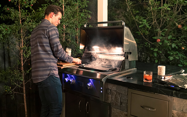 White man grilling with scotch on paver patio