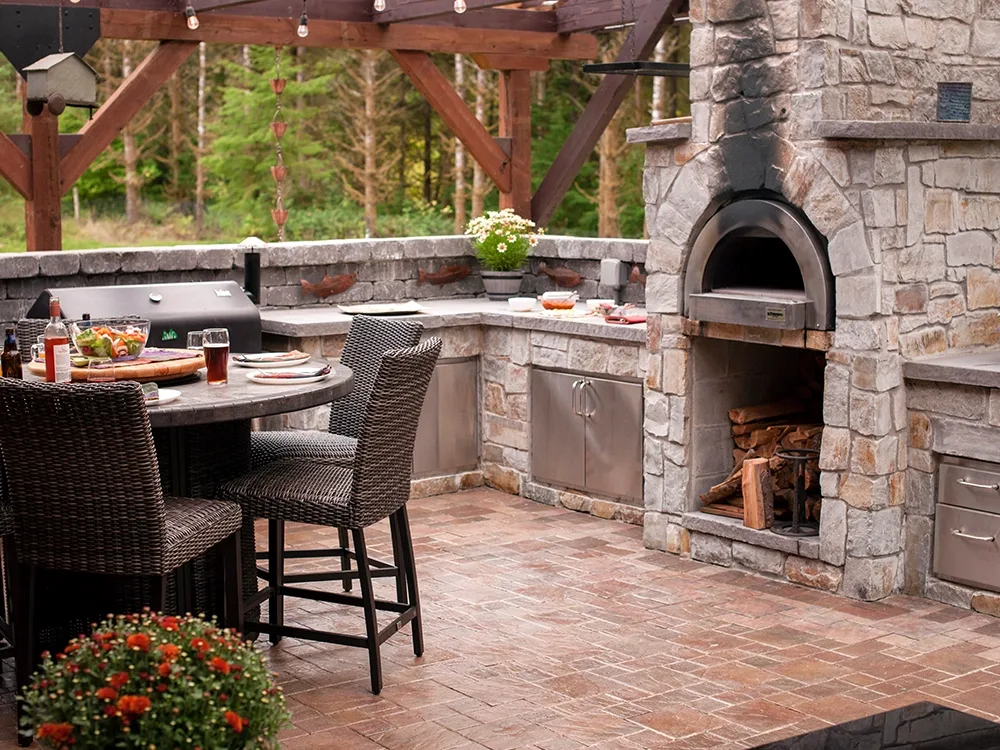Backyard kitchen with backyard pizza oven and grill.