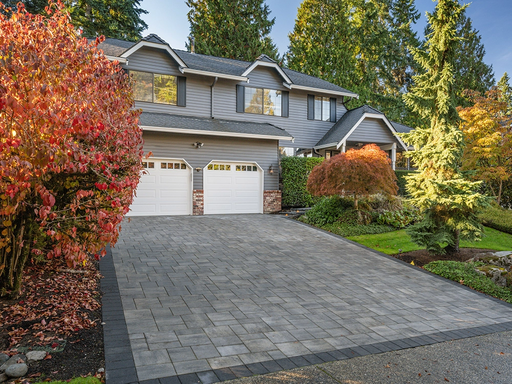 Paver driveway in front of a home in fall. 