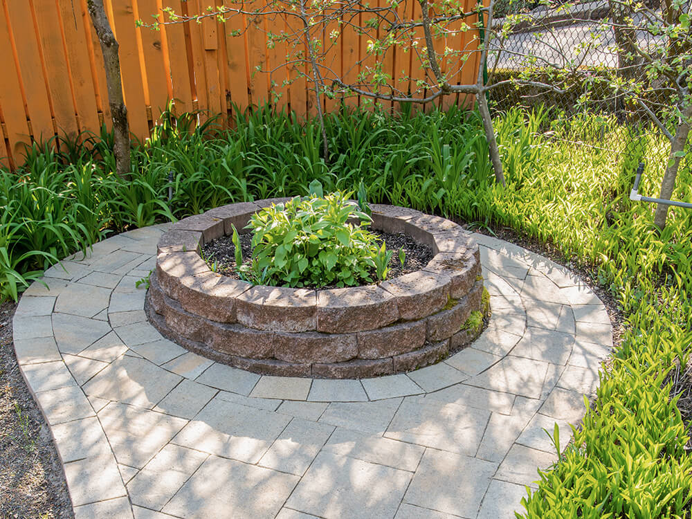 Stone circle planter made of paving stones in a Portland backyard