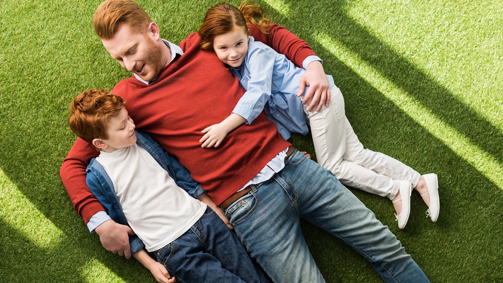 dad and kids on artificial grass