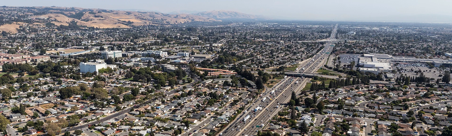 Aerial view of streets, buildings and traffic along the 880 freeway near Hayward, San Leandro and Oakland, California.