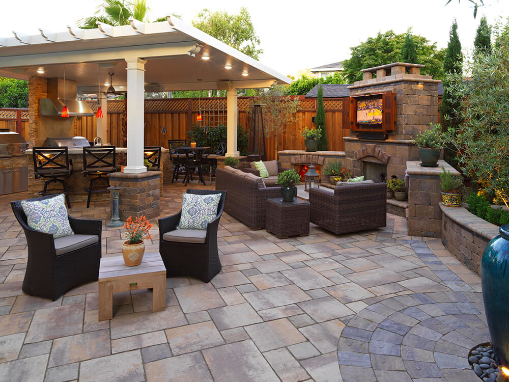 Paver stone patio with built-in TV and pergola