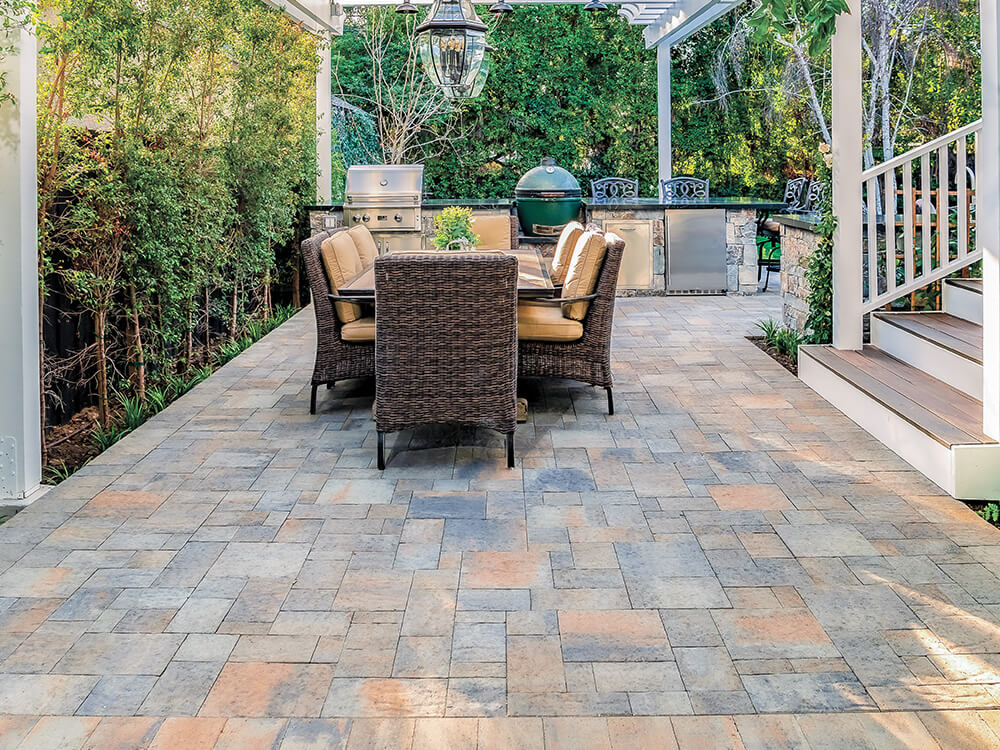 Large side paving stone patio with pergola and lighting 