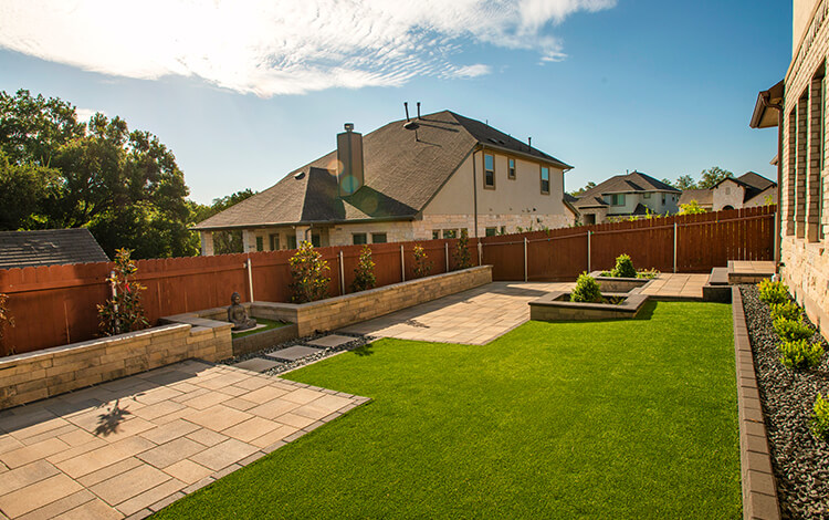 Texas backyard with artificial turf and paver insert patios