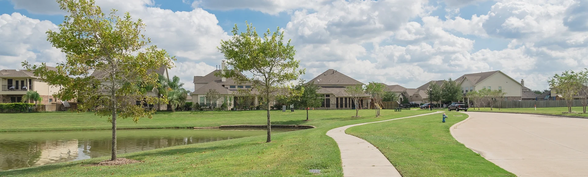 Walking pathway alongside leads to residential houses by the lake in Pearland, Texas, USA. Panorama style.