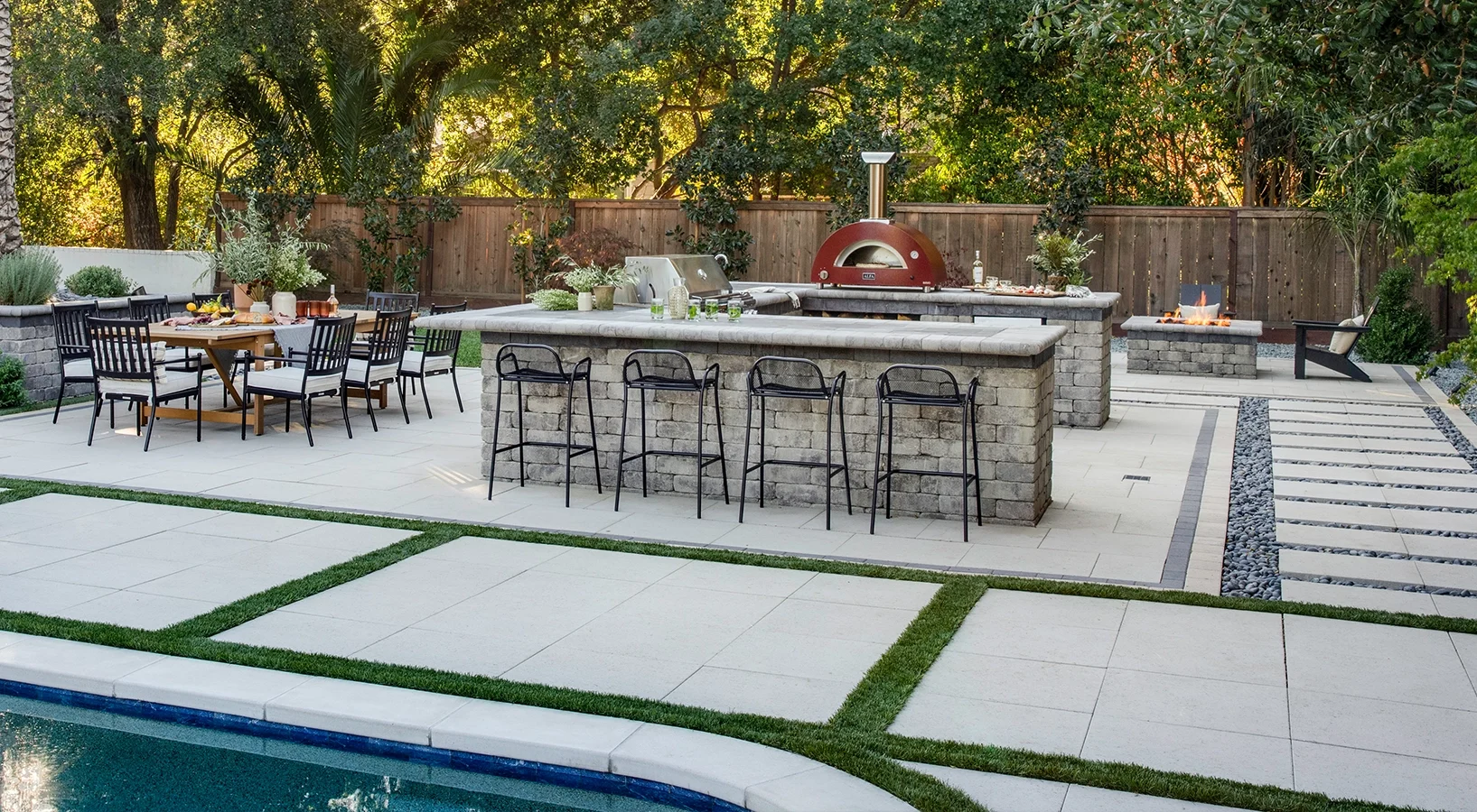 Outdoor kitchen grilling station and dining area with paver patio and turf lawn in the Pacific Northwest