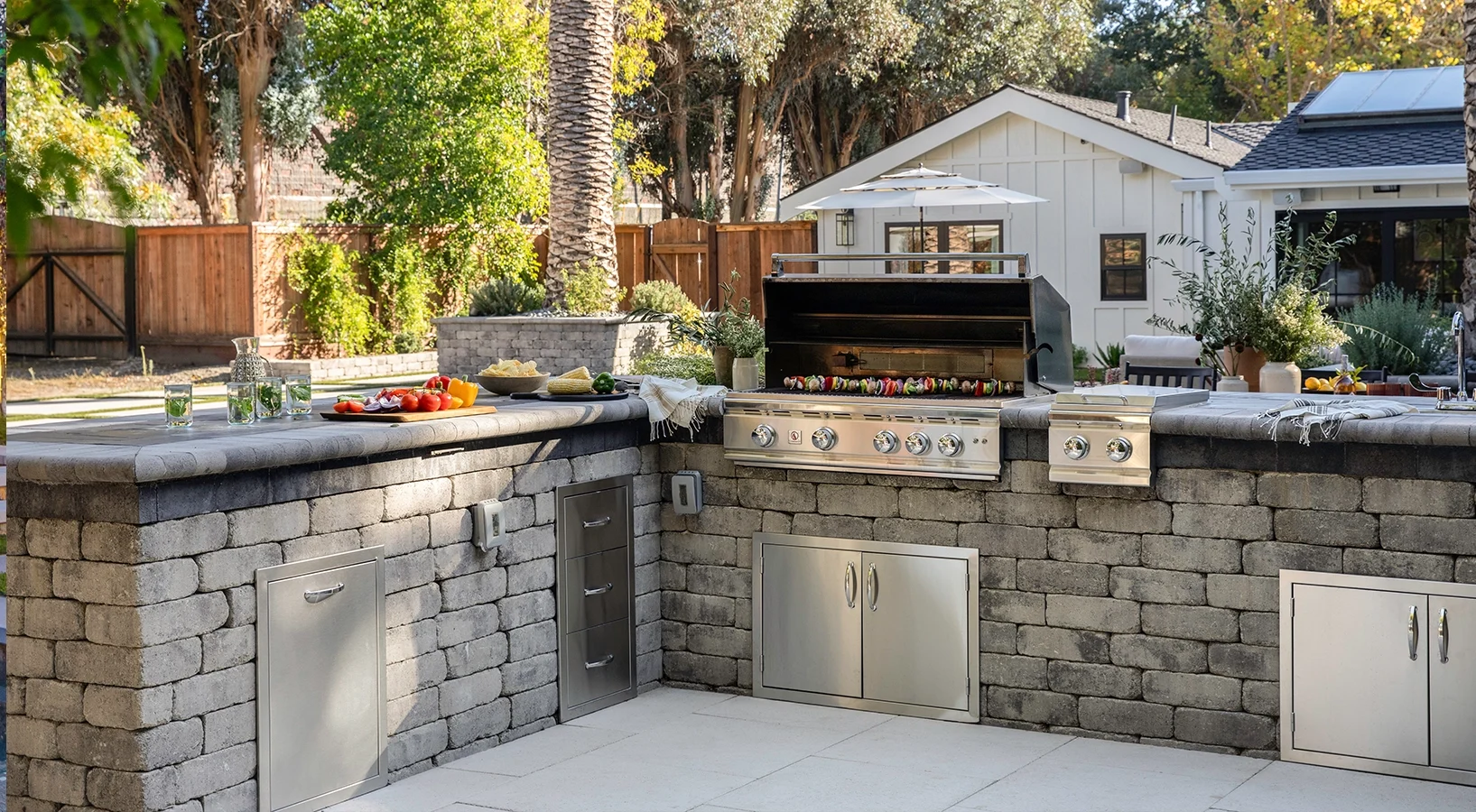 Outdoor kitchen grilling station and dining area with paver patio and turf lawn in the Pacific Northwest